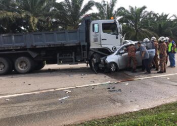ANGGOTA bomba berusaha mengeluarkan tiga beranak yang tersepit dalam Perodua Alza selepas bertembung dengan lori di Jalan Johor Kampung Pinggir, Kluang, Johor.