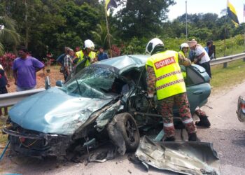ANGGOTA bomba mengeluarkan mangsa yang tersepit dalam kemalangan di Jalan Kuala Kangsar-Gerik berhampiran Restoran Tasik Raban, Lenggong hari ini. - UTUSAN/IHSAN JBPM PERAK