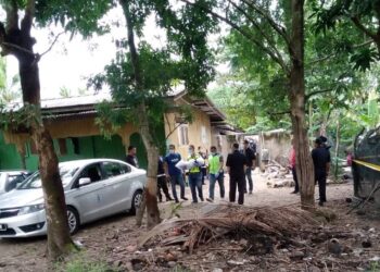 Anggota polis membawa mayat bayi lelaki yang ditemui dalam guni di sebuah rumah di  Kampung Sungai Dua, Bachok kelmarin.