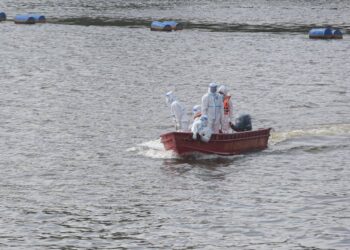 ANGGOTA Pasukan Penyelamat di Air (PPDA) menaiki bot untuk membawa mayat lelaki dewasa bergelang putih yang terapung di Sungai Terengganu di Kampung Banggul Cempedak di Kuala Terengganu, hari ini. - UTUSAN ONLINE/PUQTRA HAIRRY ROSLI