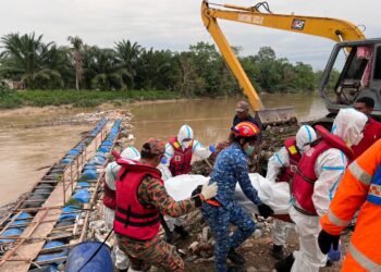 ANGGOTA bomba dan penyelamat mengalihkan mayat mangsa lemas di perangkap sampah di Labohan Dagang, Banting, Selangor.