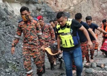 ANGGOTA bomba dan polis mengangkat mayat remaja yang ditemukan lemas di kolam takungan kuari tanah merah di Bukit Belah, Tikam Batu, Sungai Petani, semalam. - FOTO/OTHMAN YAHAYA