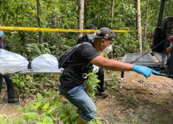 ANGGOTA polis membawa keluar mayat reput dari kawasan hutan Lata Cheng, Machang, Kelantan petang ini. - UTUSAN/TOREK SULONG