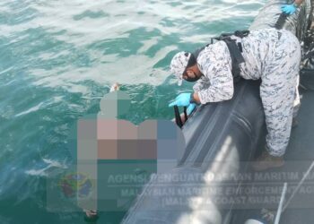 ANGGOTA Maritim Malaysia mengangkat mayat yang ditemukan terapung di Pulau Sembilan, dekat Lumut, petang semalam.  - UTUSAN/MARITIM MALAYSIA PERAK