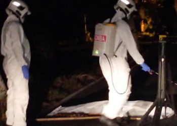 ANGGOTA bomba menyembur cecair pembasmi kuman terhadap mayat seorang warga emas di Kampung Kuantan, Kuala Selangor, Selangor. - UTUSAN/MOHAMAD NAUFAL MOHAMAD IDRIS