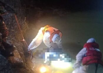 MAYAT mangsa diangkat anggota bomba lengkap berpakaian PPE selepas ditemukan terapung di sebuah kolam ikan di Kampung Sungai Buloh, Jelebu malam tadi.-FOTO/IHSAN BOMBA