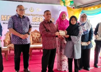 SAARANI Mohamad (tengah) menyampaikan baucar kepada penerima pada Program  Bantuan Meriah Beraya Sejahtera Bersama Kerajaan Negeri Perak di Kamunting, Taiping hari ini. - UTUSAN/WAT KAMAL ABAS