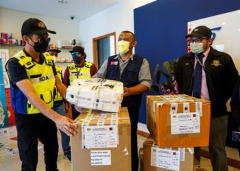 AHMAD Sharif Hambali (tengah) menunjukkan  rampasan pelbagai jenama kit ujian kendiri Covid-19 yang dibawa masuk dengan menggunakan lesen syarikat lain ketika melakukan serbuan ke atas sebuah premis perniagaan di Sungai Besi, hari ini. - UTUSAN/MOHD FARIZWAN HASBULLAH 