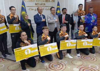 SULAIMAN Md. Ali (tengah) bersama lapan atlet kelahiran Melaka yang menyumbang pingat kepada kontinjen negara dalam majlis penyerahan insentif di Seri Negeri, Ayer Keroh, Melaka. - UTUSAN/AMRAN MULUP