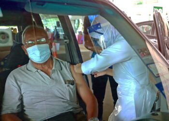 Jururawat, Siti Aminah Abdul Rahman dari Klinik Kesihatan Peringgit memberikan suntikan vaksin jenis Pfizer kepada warga emas, Mohd Sukhaimi Ibrahim, 63, di Pusat Pemberian Vaksin (PPV) pandu laludi Lapangan Terbang Antarabangsa Melaka (LTAM) di Batu Berendam. -UTUSAN/RASUL AZLI SAMAD