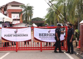 Anggota polis menutup pusat mengundi tepat pukul 5:30 petang sempena Pilihan Raya Negeri (PRN) Melaka di Sekolah Menengah Kebangsaan Bukit Katil, Melaka. - UTUSAN/RASUL AZLI SAMAD