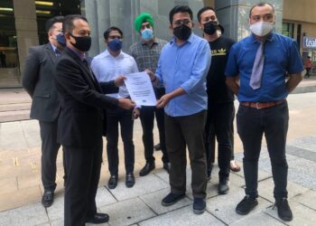 AHMAD Syukri Ab. Razab (kanan) menyerahkan memorandum bantahan kepada Mohd. Ariffin A.M Noordin di perkarangan KPDNHEP, Putrajaya. - UTUSAN/SUBKHI SUDARJI