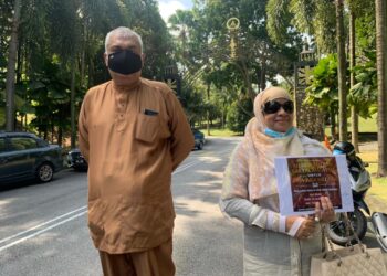 MAIMUNAH Sargeant (kanan) memegang salinan memorandum yang dihantar kepada SSultan Sharafuddin Idris Shah di Istana Bukit Kayangan, Shah Alam, hari ini.