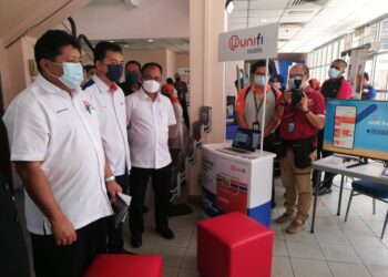 MAZLAN Bujang (kiri) meninjau ruang pameran TMUnifi selepas taklimat penerangan Liputan Internet dan Telekomunikasi Negeri Johor di Auditorium RTM, Johor Bahru.