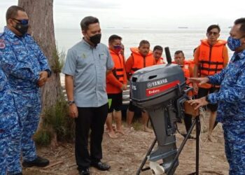SHAMSUL Ridzuan Idris (tiga dari kiri) dan Noor Azam Johari (dua dari kiri) mendengar penerangan mengenai enjin bot pada majlis penutup Latihan Lanjutan Pengendalian Bot APM peringkat negeri di pantai Teluk Batik, Lumut, Perak, hari ini. - FOTO/SHAMSUL KAMAL AMARUDIN