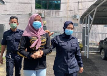SITI Fazira Mohd. Sofian (tengah) yang dituduh melakukan khianat di rumah madunya dibawa keluar dari Mahkamah Majistret Kemaman di Kemaman, Terengganu, hari ini. - UTUSAN/NIK NUR IZZATUL HAZWANI NIK ADNAN
