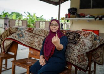 JURIAH Mohd Desah selesai menunaikan tanggungjawab mengundi walaupun mengenang rumahnya kotor ditenggelami banjir di Bangi, Selangor.- UTUSAN/FARIZ RUSADIO