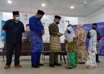 ADHAM Baba (tengah) menyampaikan sumbangan kepada kanak-kanak sempena majlis Minggu Sains Negara Keluarga Malaysia 2022 dan Ihya Ramadan Tenggara di di Dewan Seri Kembaran, Bandar Tenggara, Kota Tinggi, Johor.