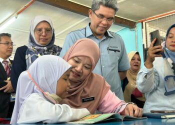 FADHLINA Sidek bersama seorang murid ketika melawat  (SK) Chepor, Chemor di Ipoh hari ini. - UTUSAN