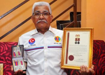 ZAKARIA Che Seman menunjukkan Pingat Jasa Malaysia  yang diterima daripada kerajaan ketika ditemui di rumahnya di Taman Bukit Tiram, Ulu Tiram di Johor semalam. – UTUSAN/RAJA JAAFAR ALI