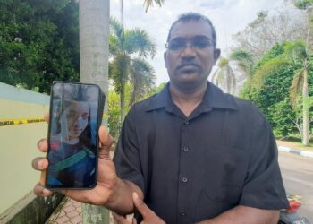 YUSUFF Merican Kadir Shah Merican menunjukkan gambar sepupunya yang ditemukan rentung di Taman Bayam Indah, Lunas di Kulim. -UTUSAN/AZAHAR HASHIM