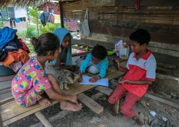 Kanak-kanak dari masyarakat Orang Asli suku kaum Kensiu berkongsi menggunakan  telefon pintar di Kampung Lubuk Legong, Baling, Kedah. pada awal tahun ini. - MINGGUAN/Shahir Noordin
