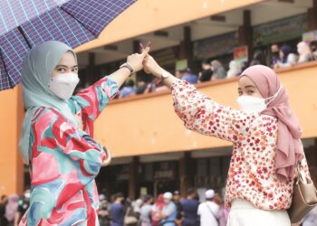 Pengundi muda, Nur Izzati Mohd. Rasol (kiri) bersama adiknya Nur Hanani selepas mengundi pada Pilihan Raya Umum ke-15  di Melaka.  - Gambar hiasan