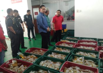 SAHARUDDIN Mohd Kia (dua, kanan) memeriksa sebahagian minyak masak di sebuah kilang pembungkusan minyak masak di Kampung Binjai, Dungun, Terengganu, hari ini. - UTUSAN/NIK NUR IZZATUL HAZWANI NIK ADNAN