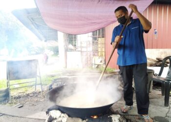 MASNAWI Yusof mengacau dodol untuk jualan meskipun kehadiran pelanggan ke kedainya di Hutan Simpan Sungai Udang, Melaka terjejas ekoran pelaksanaan PKP. - UTUSAN/MUHAMMAD SHAHIZAM TAZALI