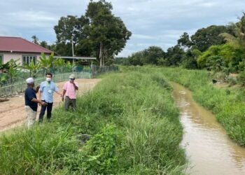 NG Choon Koon (tengah) meninjau keadaan sungai di Kampung Lubuk Kasau, Bemban, Melaka yang menyebabkan banjir setiap kali hujan lebat. - FOTO/DIYANATUL ATIQAH ZAKARYA