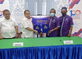 ABDUL Fattah Abdullah (dua dari kiri) bertukar dokumen dengan Koperasi Pekerja-pekerja Kumpulan Sokongan Melaka Berhad di Ayer Keroh, Melaka. - FOTO/AMRAN MULUP