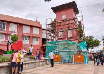 PELANCONG gemar menjadikan tulisan I Love Melaka sebagai latar gambar namun keadaan menara jam di Banda Hilir, Melaka yang sedang dalam proses penyelenggaraan merencatkan pemandangan. - UTUSAN/MUHAMMAD SHAHIZAM TAZALI