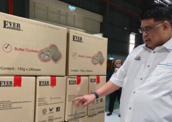 AB. Rauf Yusoh melihat pembungkusan produk ketika mengadakan lawatan kerja ke sebuah kilang pemprosesan makanan di Telok Mas, Melaka. - FOTO/MUHAMMAD SHAHIZAM TAZALI