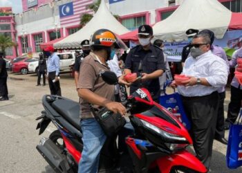 RAZALI Abu Samah menyampaikan bubur lambuk kepada orang ramai pada Kempen Keselamatan Rumah dan pengedaran bubur lambuk sempena Ramadan di Ayer Keroh, Melaka. - FOTO/DIYANATUL ATIQAH ZAKARYA