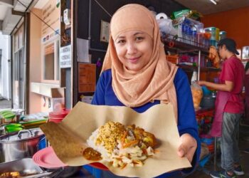 NIK Haznita Yusuf menunjukkan Menu Rahmah yang dijual di gerainya di Masjid Tanah, Melaka. - UTUSAN/MUHAMMAD SHAHIZAM TAZALI