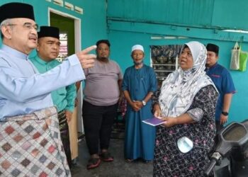 MOHD. ALI Mohd. Rustam (kiri) bertanyakan sesuatu kepada mangsa ribut ketika menziarahi empat kampung terlibat di Tanjung Bidara, Masjid Tanah, Melaka. - FOTO/AMRAN MULUP 