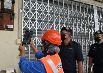 LIM Meng Seah melihat pemotongan bekalan elektrik dibuat kakitangan TNB dalam serbuan di sebuah premis di Tanjung Kling, Melaka. - FOTO/DIYANATUL ATIQAH ZAKARYA