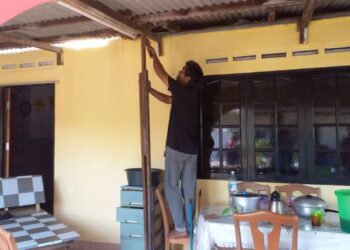 SEORANG penduduk sedang membaiki bumbung rumah yang rosak dilanda ribut di Kampung Pasir Gembur, Tanjung Bidara, Masjid Tanah, Melaka. - FOTO/AMRAN MULUP