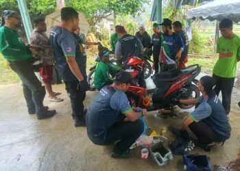 SEBAHAGIAN ahli NGO yang menawarkan perkhidmatan membaiki motosikal mangsa yang ditenggelami air di Kampung La, Besut, hari ini.