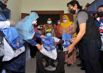 ZURAIDAH Kamaruddin (dua dari kiri) menyampaikan cenderamata kepada seorang warga emas setelah menerima suntikan vaksin sambil diperhatikan oleh Halimah Mohamed Sadique (dua dari kanan) sempena Program MOVAK di PPV Dewan Muafakat Taman Adda di Johor Bahru, Johor. -UTUSAN/RAJA JAAFAR ALI