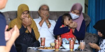 ROSNAZIRAH Mohd. Naim (dua dari kanan) bersama anak dan kedua ibu bapa mengaminkan doa di rumah suaminya di Jalan Kelochor, Kota Bharu, Kelantan hari ini. - UTUSAN/KAMARUL BISMI KAMARUZAMAN 