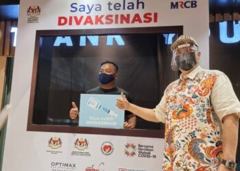 Menteri Wilayah Persekutuan, Tan Sri Annuar Musa (kanan)  bersama seorang kakitangan MRCB yang telah menerima suntikan vaksin menerusi inisiatif Trak Vaksin Bergerak MyMedic@Wilayah.
