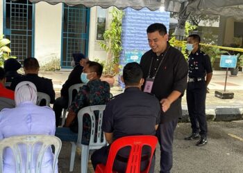 MUHAMMAD Noor Azman menyantuni anggota polis yang menjalani proses pengundian awal sempena PRU15 di Meru Kapar, Selangor. - UTUSAN/ABDUL RAZAK IDRIS