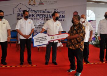 HASNI Mohammad (tiga kiri) menyerahkan replika kunci kepada salah seorang penduduk sempena Sesi Penyerahan Kunci Projek Perumahan Kampung Pendas Baru Fasa 2 di Pendas Laut di Iskandar Puteri, Johor. - UTUSAN/RAJA JAAFAR ALI