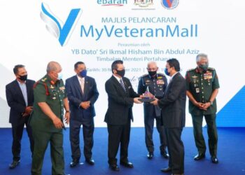 IKHMAL HISHAM ABDUL AZIZ menyampaikan anugerah kepada seorang penerima pada majlis pelancaran  MyVeteran Mall di Hotel Royale Chulan, Kuala Lumpur.