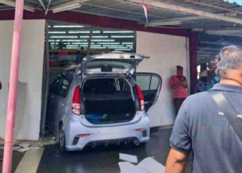 KERETA Myvi yang dipandu wanita warga emas merempuh sebuah kedai pakaian di Seri Manjung, Perak, semalam.  - MEDIA SOSIAL