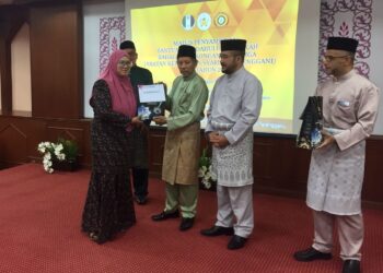 WAN Mohd. Zakri (kanan) mengiringi Shaikh Harun Shaikh Ismail menyerahkan bantuan pendahuluan nafkah kepada salah seorang penerima di Kuala Terengganu, hari ini. - UTUSAN/TENGKU DANISH BAHRI TENGKU YUSOFF