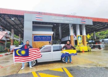 RUSHAFIZI Indrus (kanan) dan Nor Azman Musa (kiri) memulakan perjalanan mereka menaiki kereta Perodua Kancil di pintu sempadan Wang Kelian, bagi kembara menuju ke Thailand dan Laos hari ini. -UTUSAN