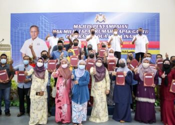 HASNI Mohammad (belakang, tengah) bersama penerima selepas menyampaikan geran Hak Milik Tapak Rumah (Tapak Ganti) Generasi Kedua Felda Inas di Dewan Semai Bakti Felda Inas, Kulai, Johor.