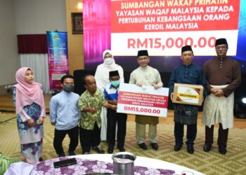 MOHD. Na'im Mokhtar (tiga dari kanan) menyerahkan sumbangan Wakaf Prihatin Yayasan Waqaf Malaysia kepada Pertubuhan Kebangsaan Orang Kerdil Malaysia di Putrajaya. - UTUSAN/MOHD HUSNI MOHD NOOR